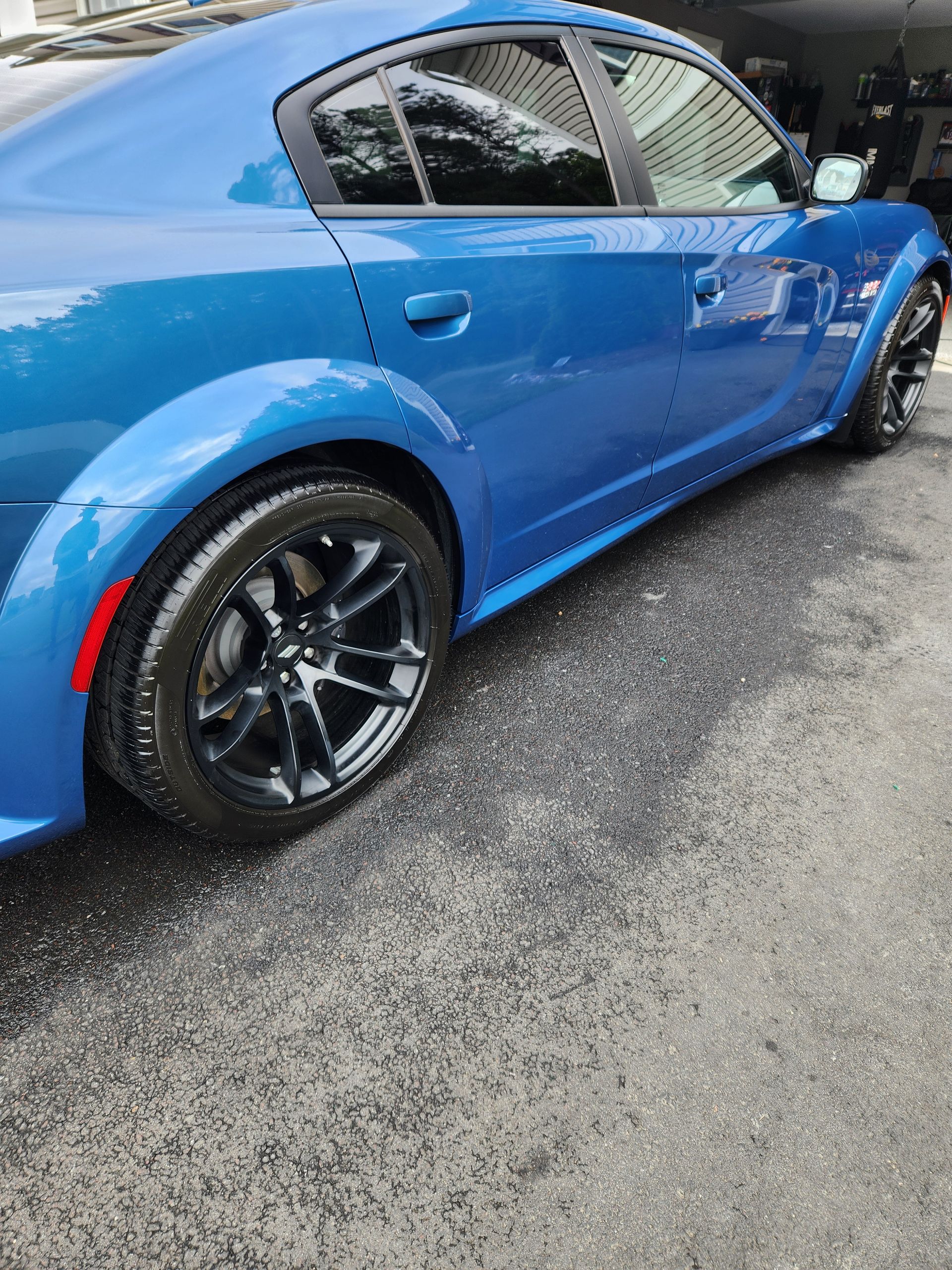 A blue dodge charger is parked on the side of the road.