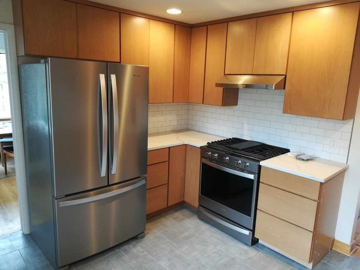 Family gathered at a dining table in a kitchen. They are eating and talking together.