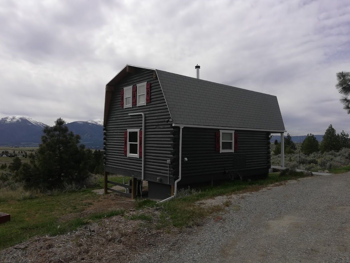 A person holding a baby up in the air indoors near a window, baby smiling.