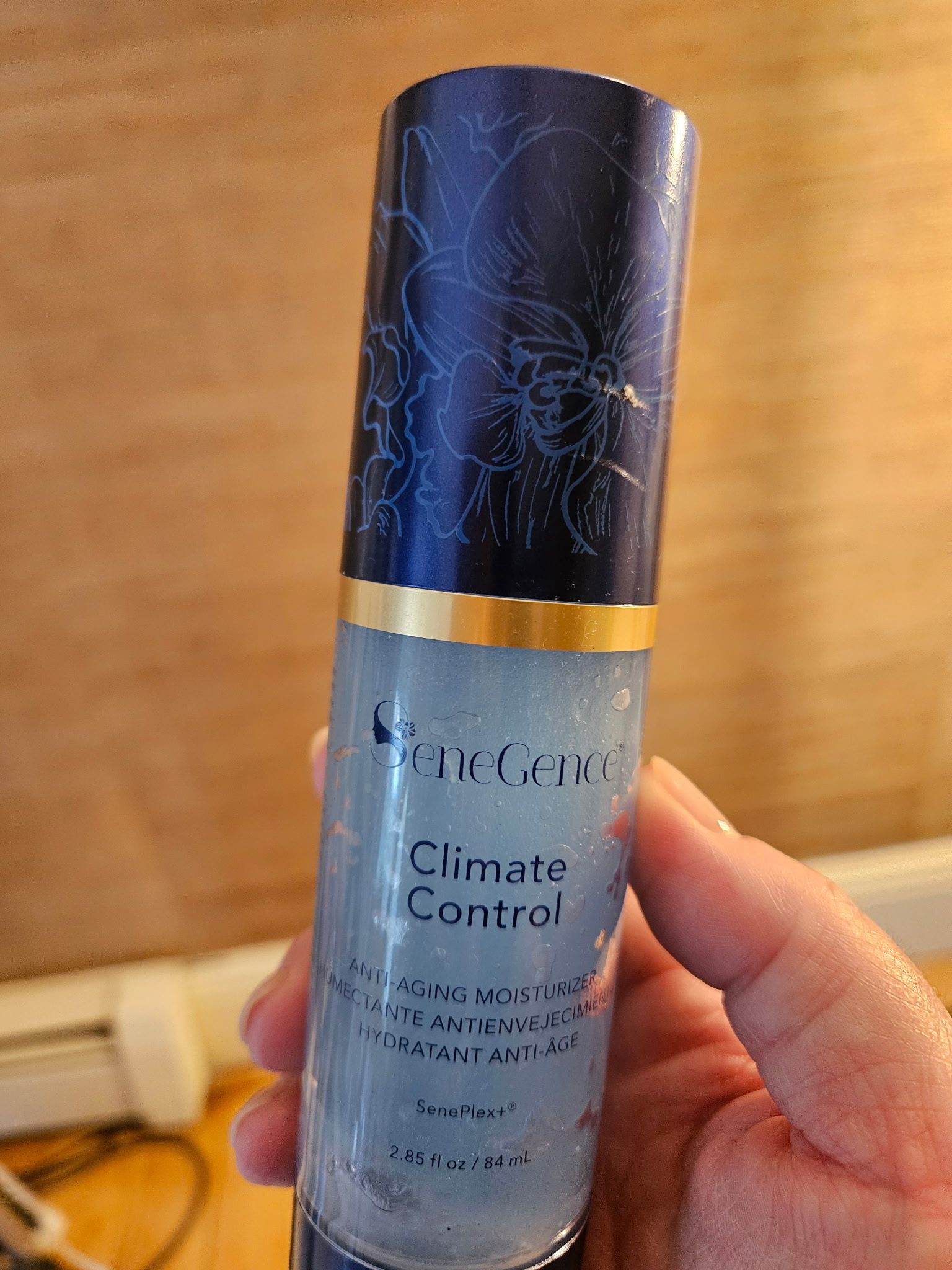 A hand holds a bottle of 