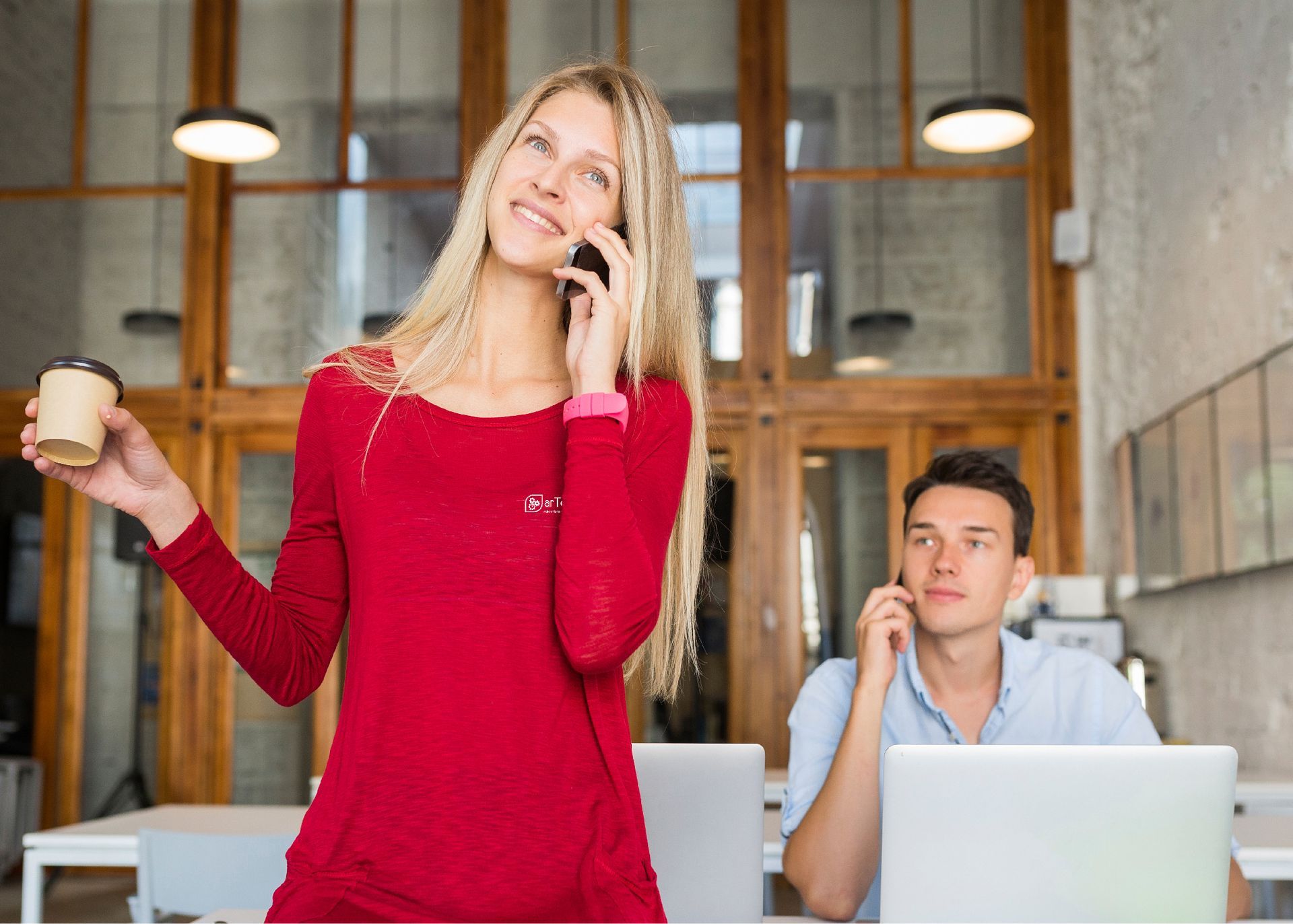 Una mujer está parada junto a un hombre hablando por un teléfono celular.