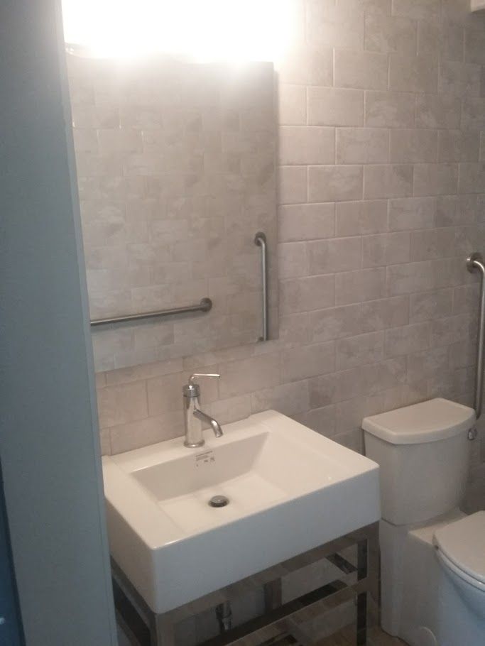 A bathroom with a sink , toilet and mirror.