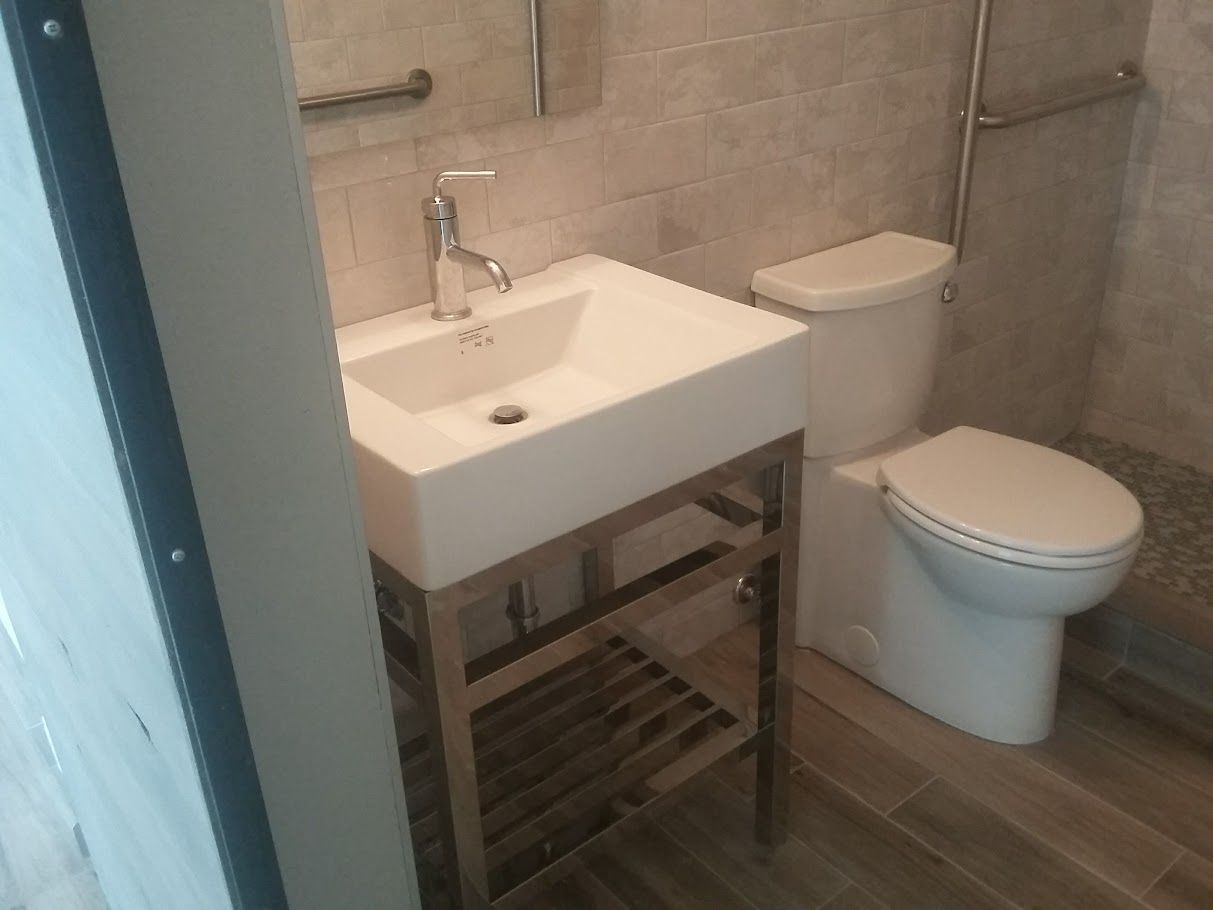 A bathroom with a toilet , sink and mirror