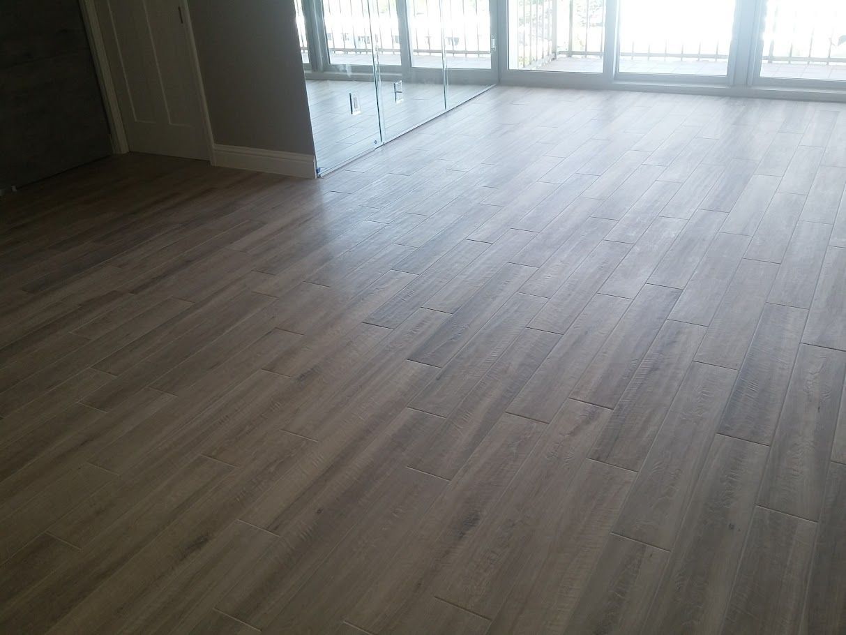 A living room with a wooden floor and a large window.