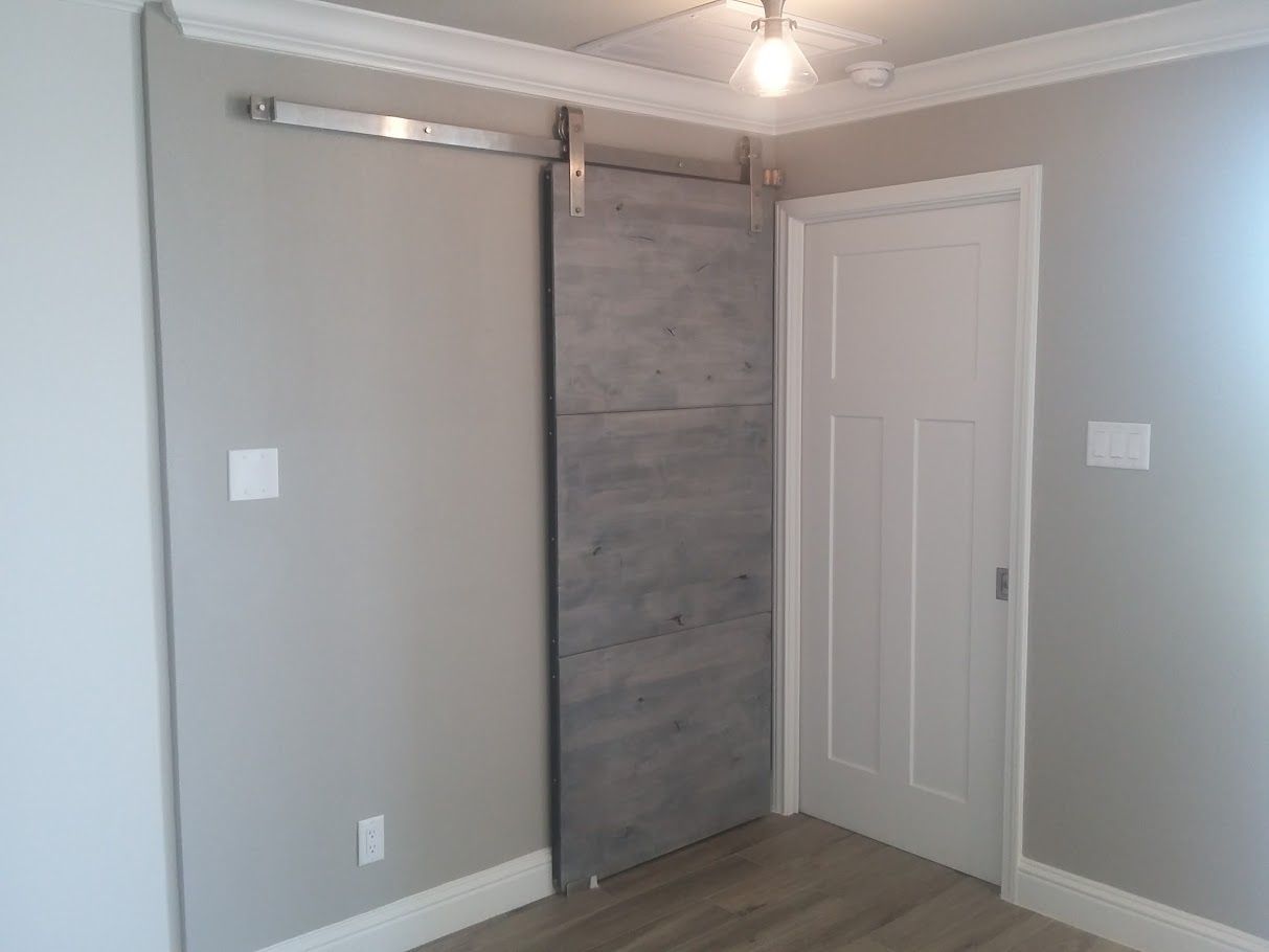 There is a sliding barn door in the corner of the room.