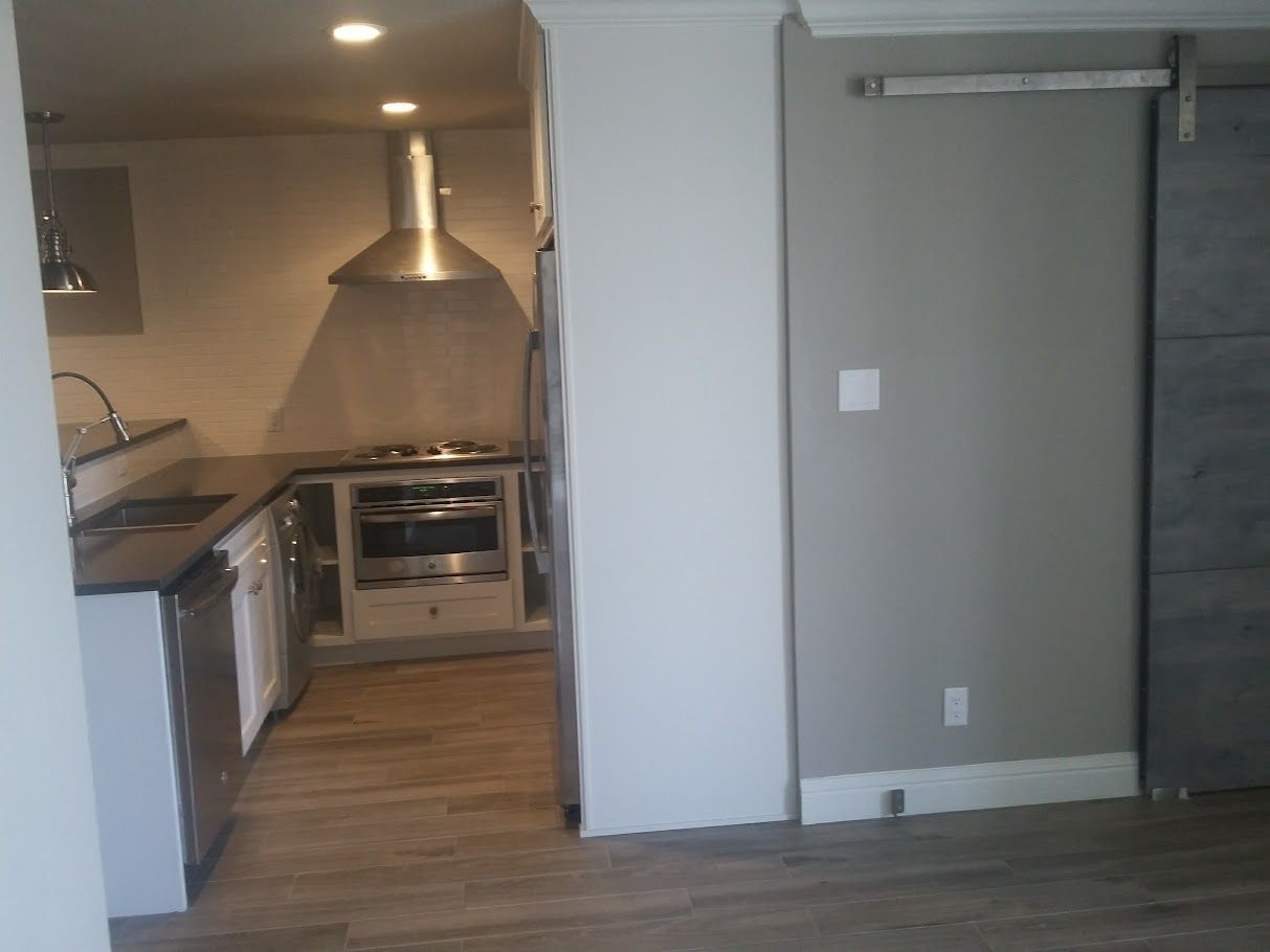 A kitchen with stainless steel appliances and wooden floors