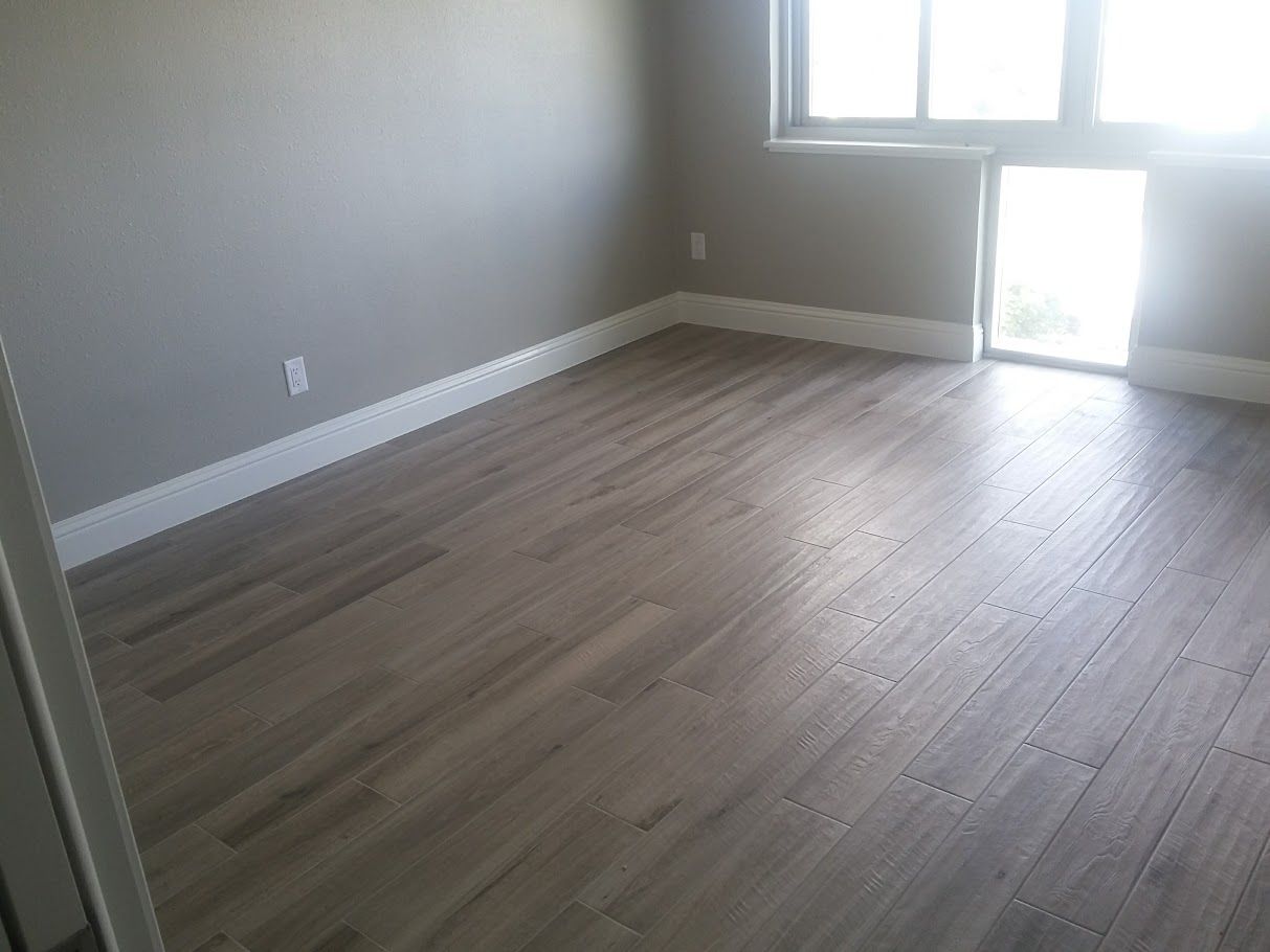An empty room with hardwood floors and a window.