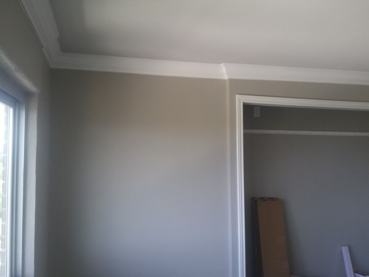 A room with gray walls and white trim and a window