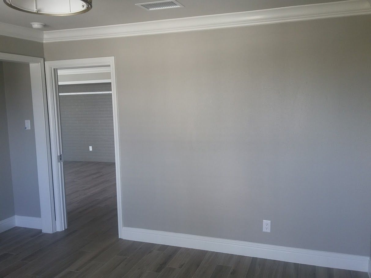 An empty room with gray walls and white trim