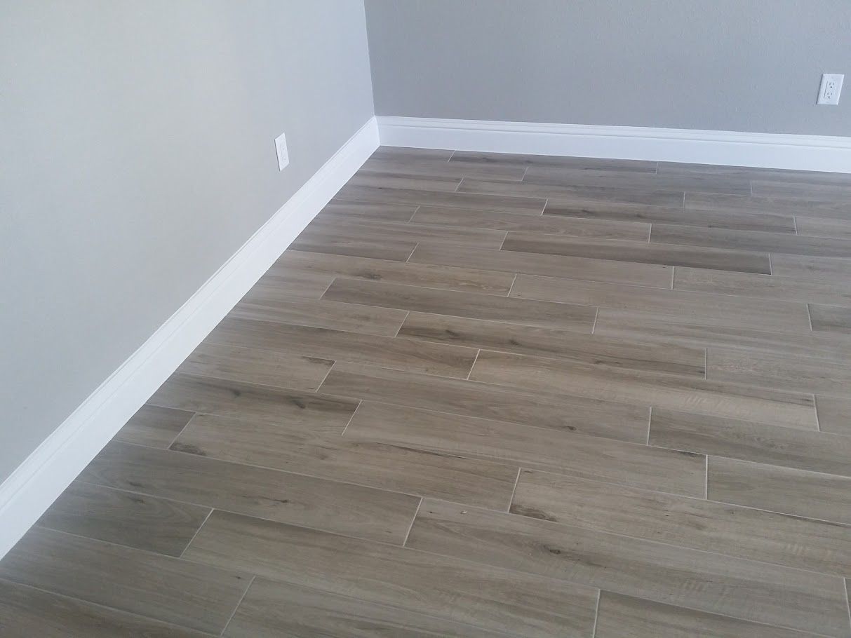 A room with a wooden floor and a white wall.