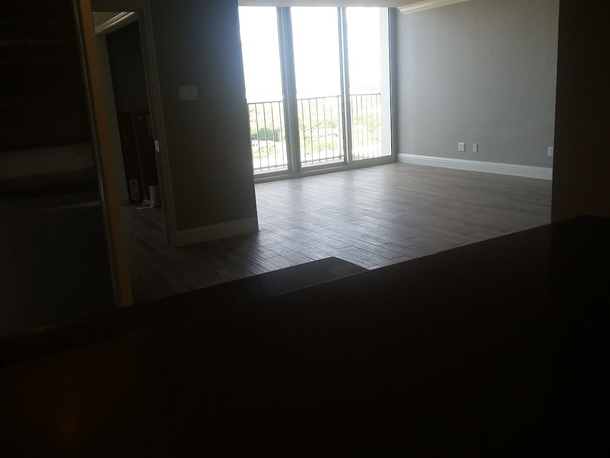 An empty room with a lot of windows and a balcony.