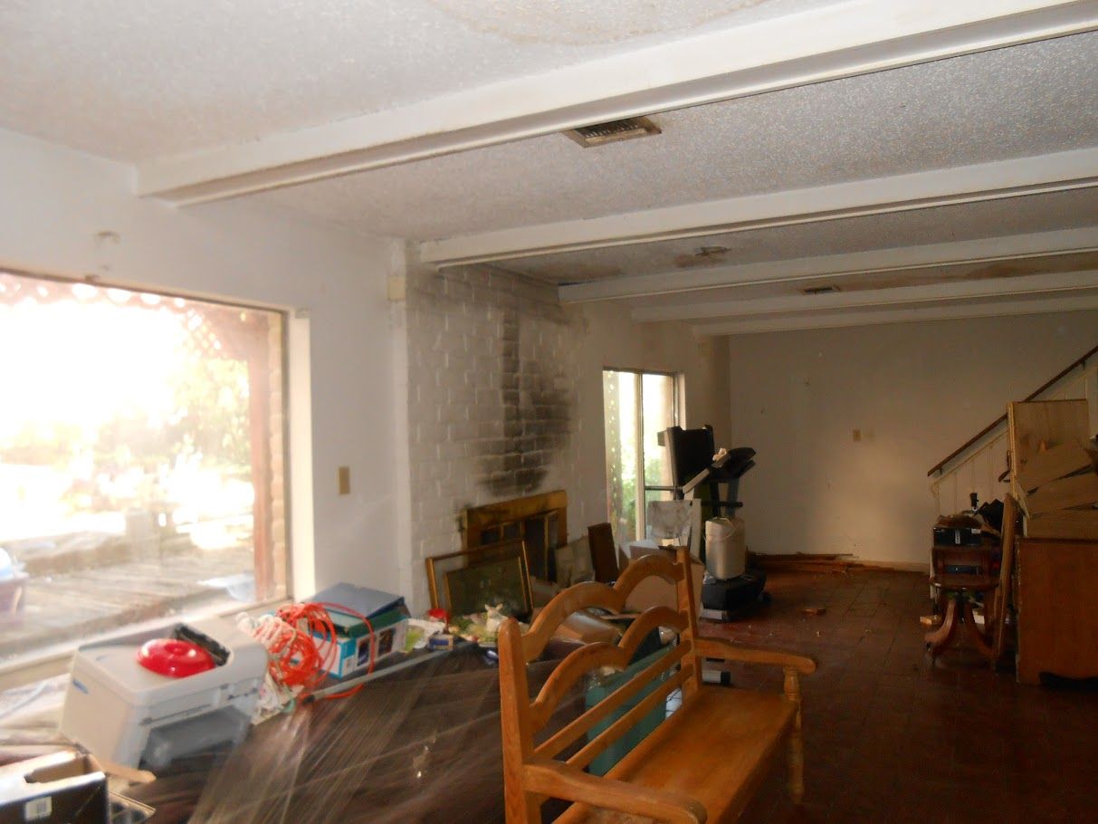 An empty living room with a bench and a fireplace