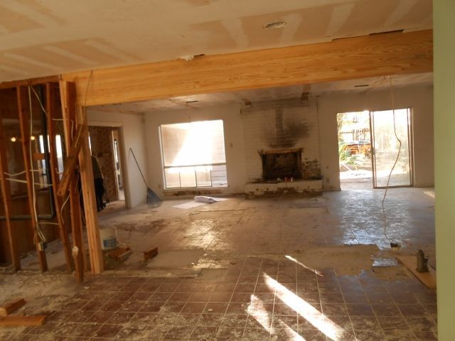 An empty room with a fireplace and sliding glass doors