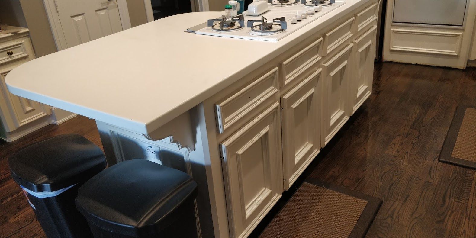 A kitchen with a large island and a stove top oven.