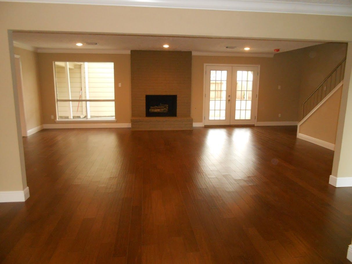 An empty living room with hardwood floors and a fireplace