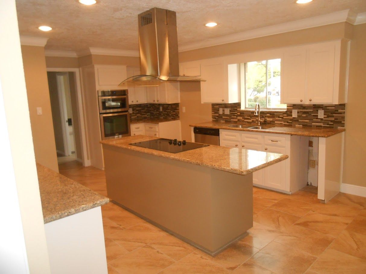 A kitchen with stainless steel appliances and granite counter tops.