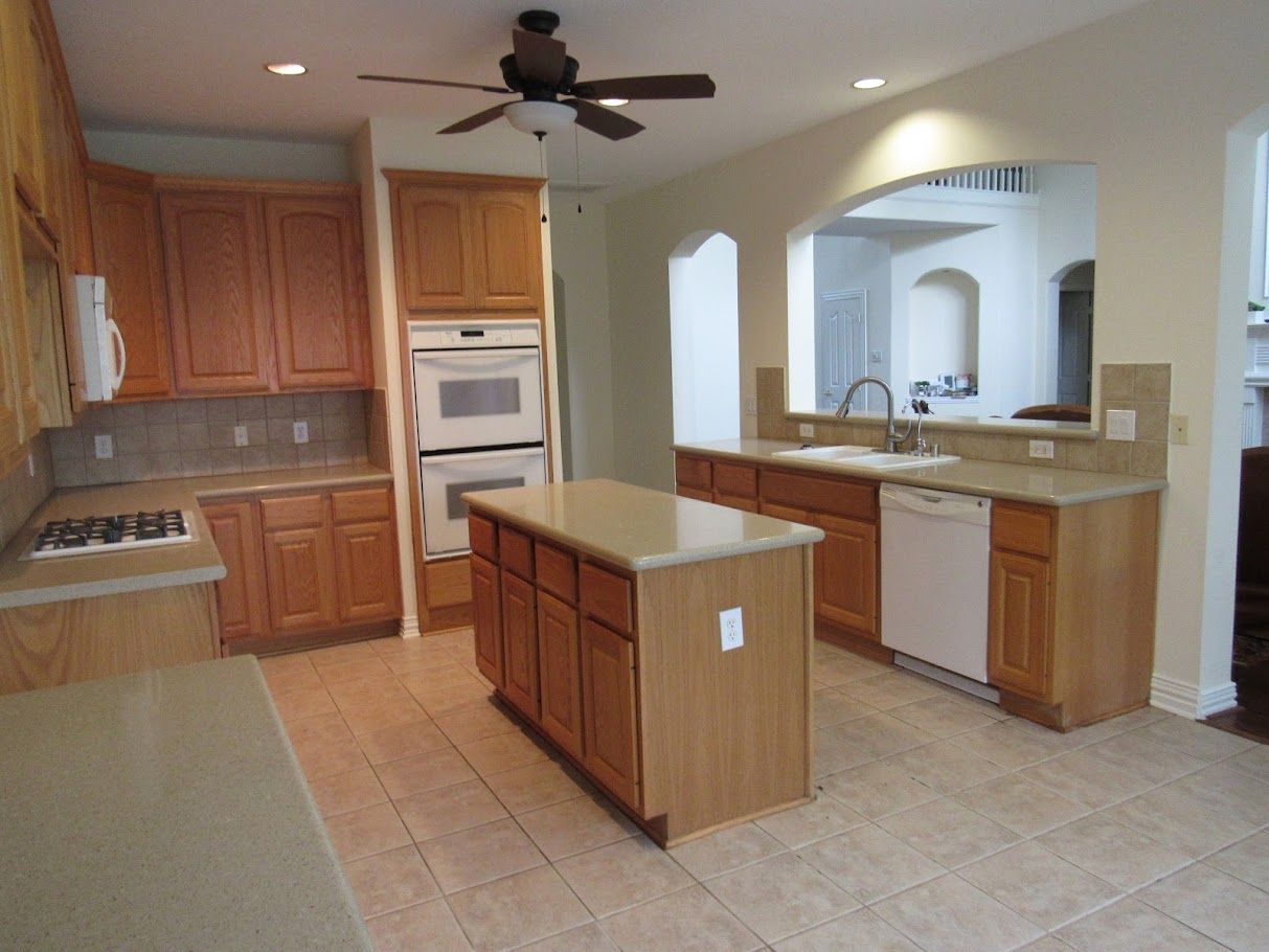 A kitchen with a large island and a ceiling fan