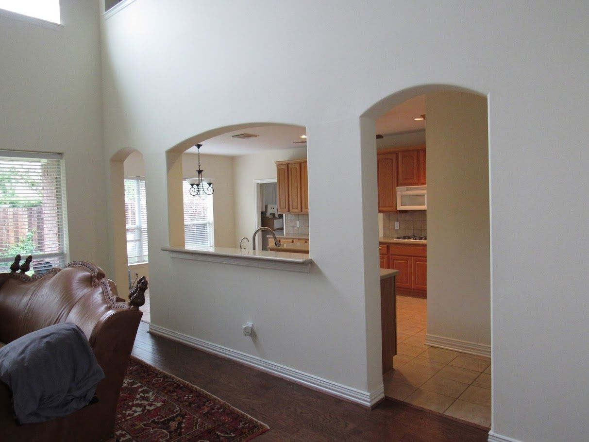 A living room with a couch and a kitchen in the background