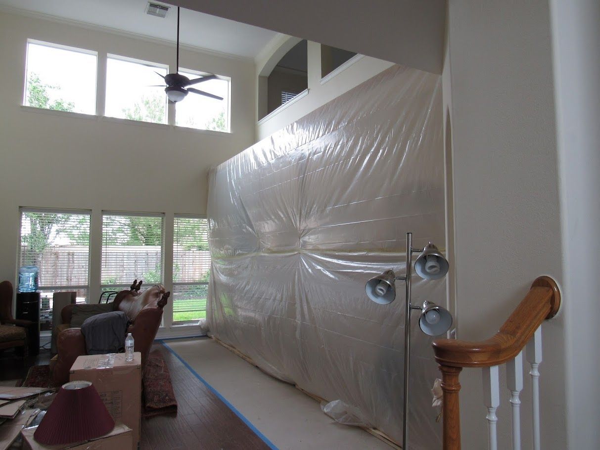 A living room with a large wall covered in plastic
