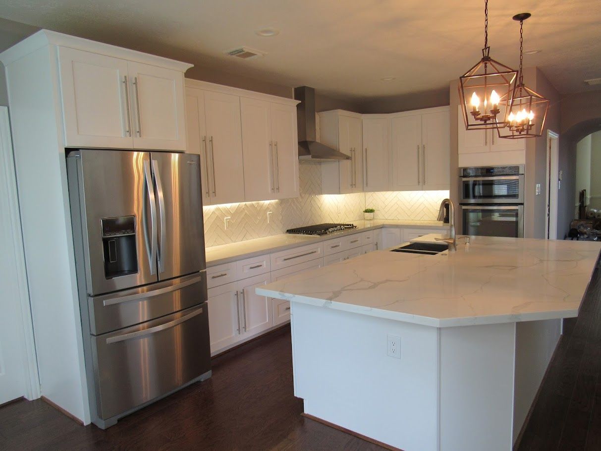 A kitchen with stainless steel appliances and white cabinets