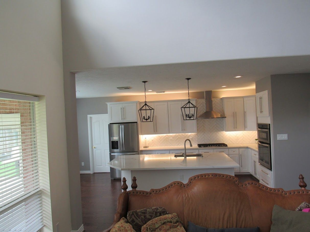 A living room with a couch and a kitchen in the background
