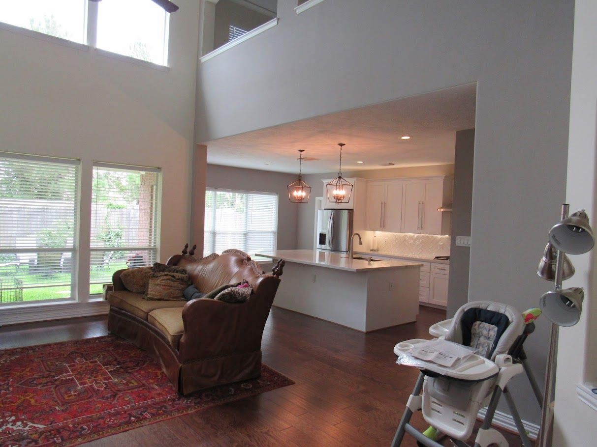 A living room with a couch and a high chair in it