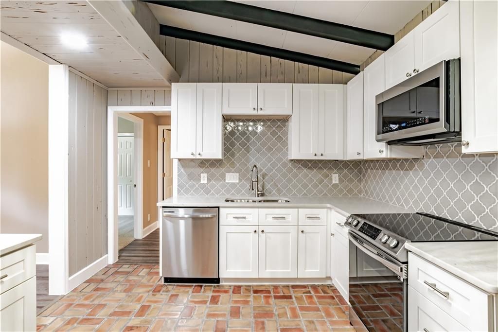 A kitchen with white cabinets and stainless steel appliances