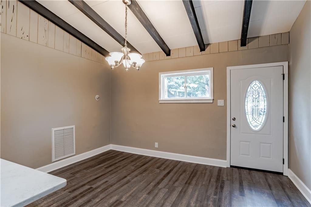 An empty room with a white door and a window.