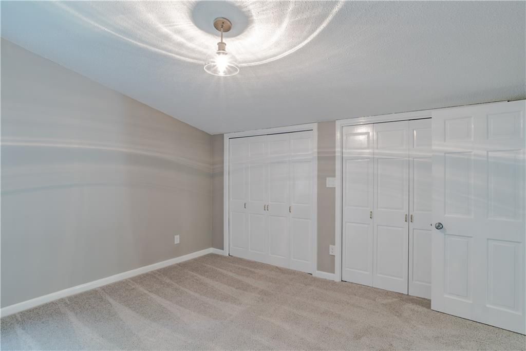 An empty bedroom with a lot of closets and a chandelier.