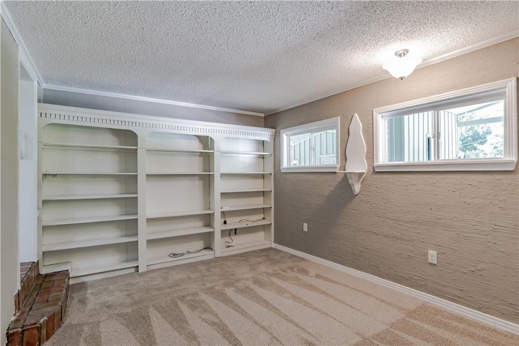 An empty room with a lot of shelves and a window