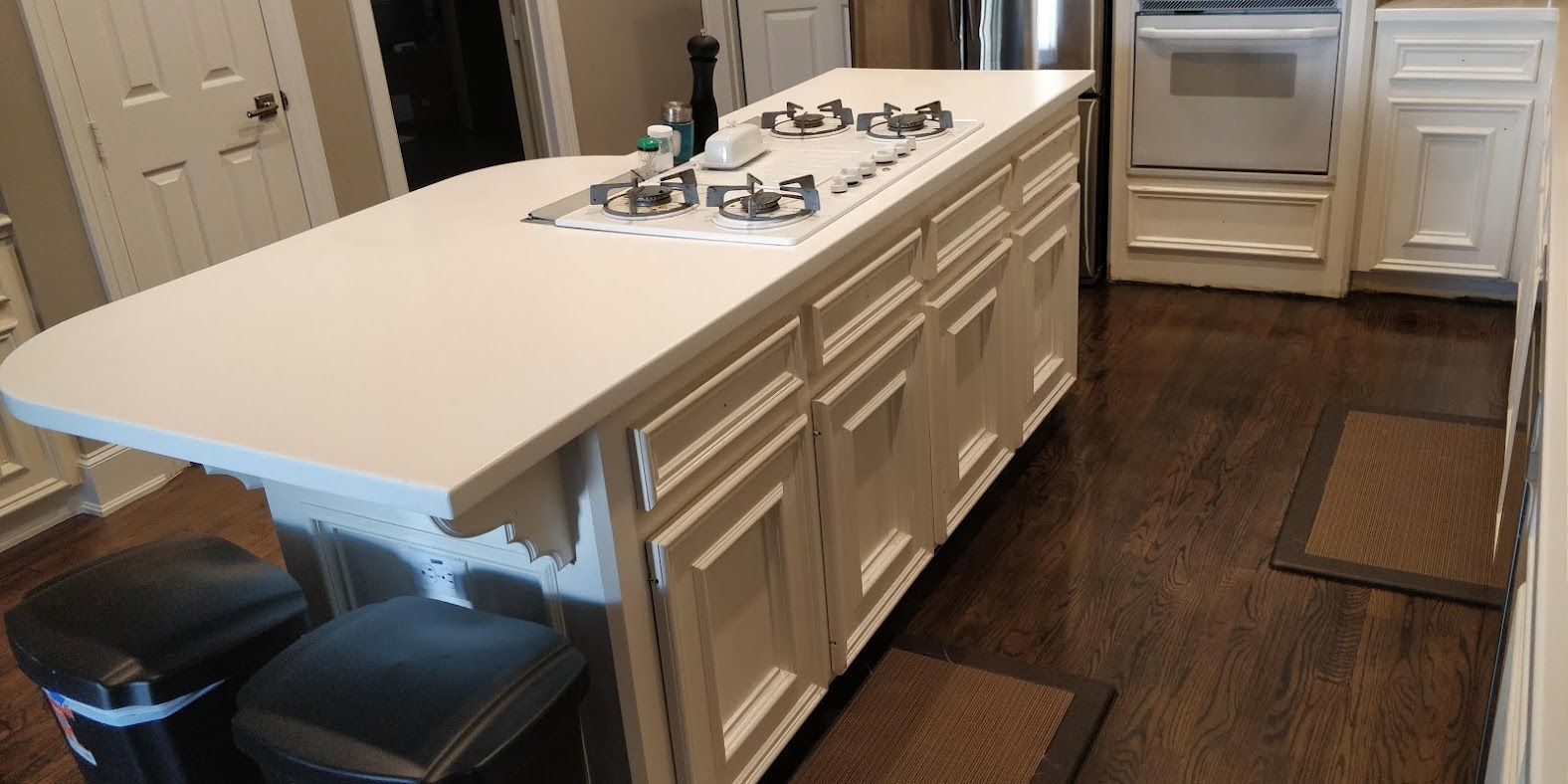 A kitchen with a large island with a sink and stove top oven.