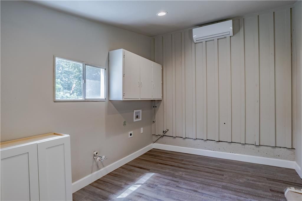 An empty room with a washer and dryer and a window.