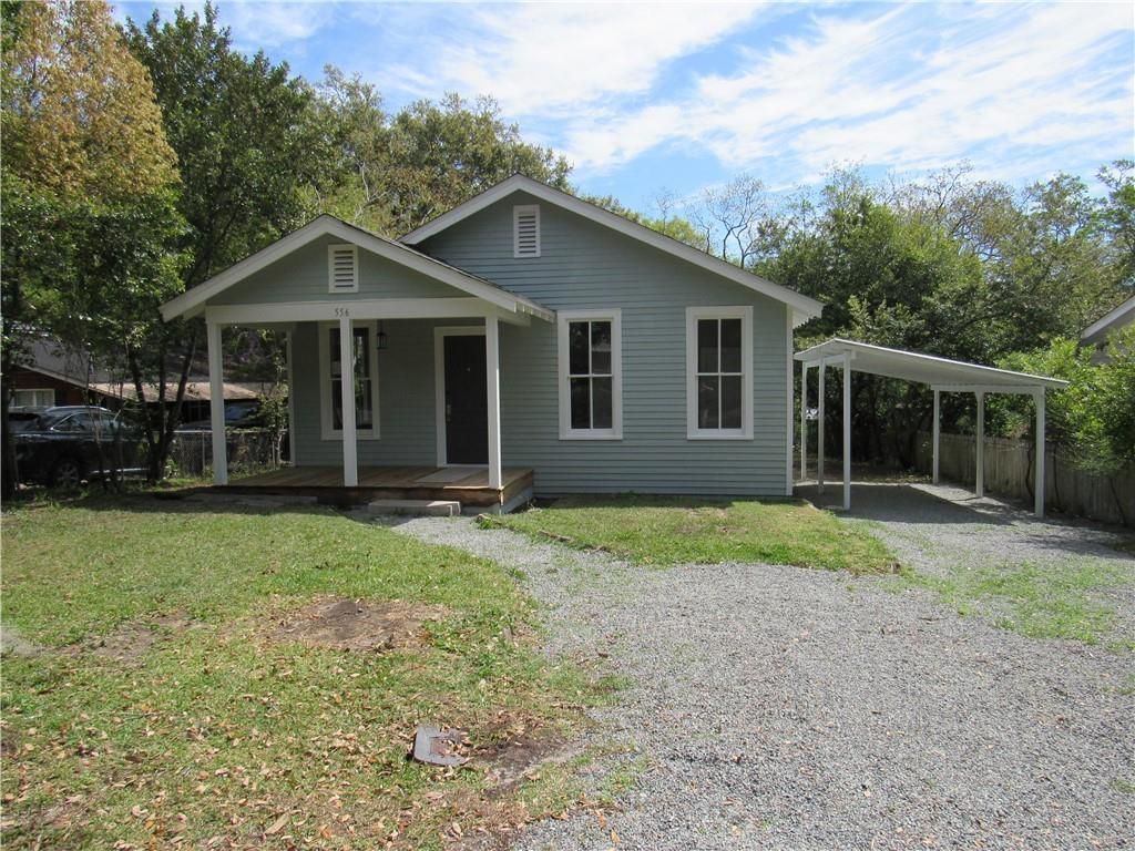 A small house with a carport in front of it