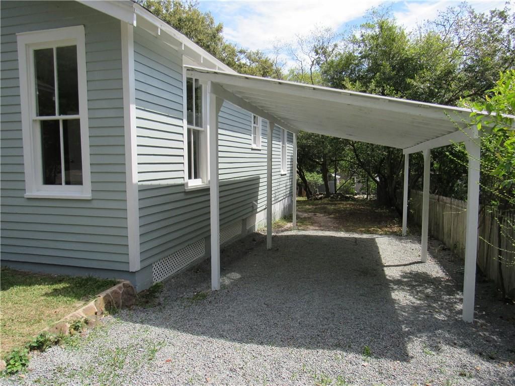 A carport is attached to the side of a house.