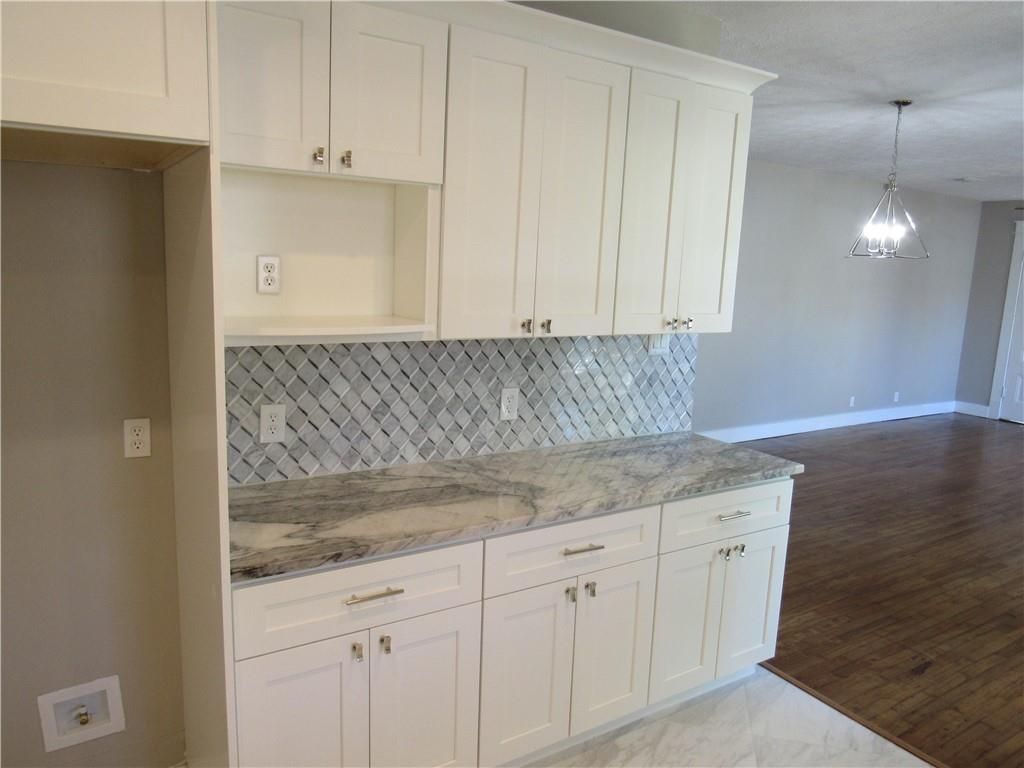 A kitchen with white cabinets and granite counter tops