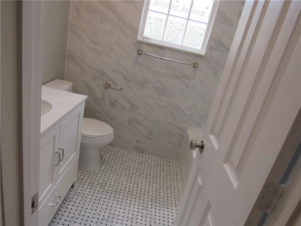 A bathroom with a toilet a sink and a window