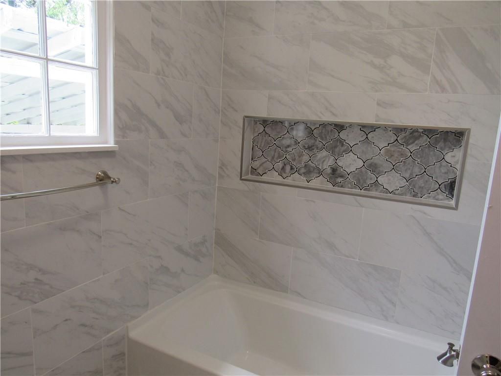 A bathroom with a bathtub and a window.