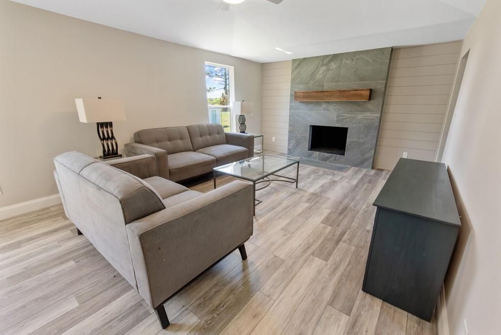 A living room with a couch , chair , coffee table and fireplace.