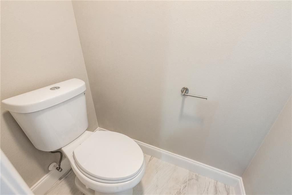 A toilet is sitting in a small bathroom next to a wall.