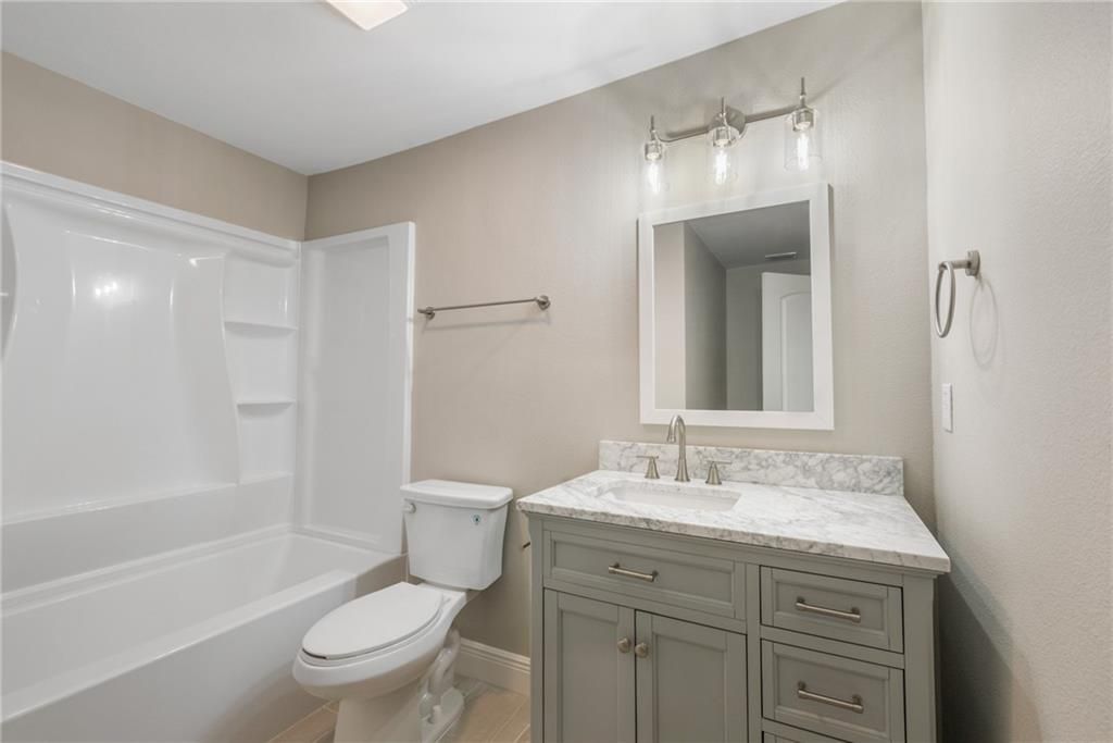 A bathroom with a toilet , sink , and bathtub.