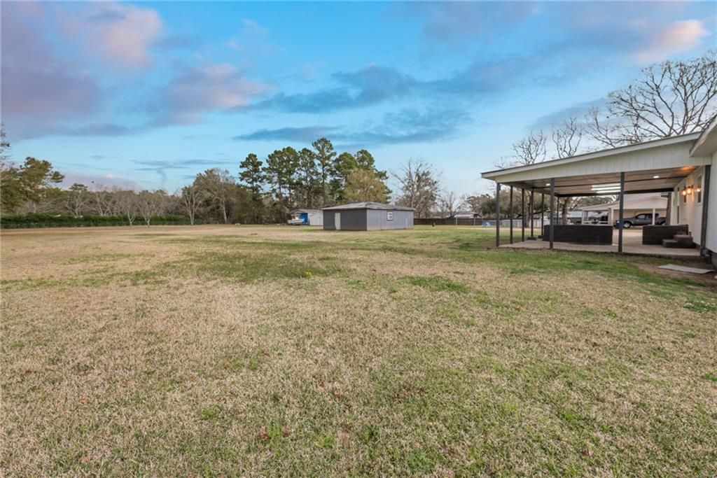 A large grassy field with a house in the background.