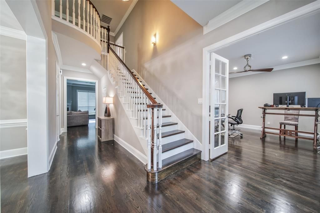 A large hallway with a staircase leading up to the second floor of a house.