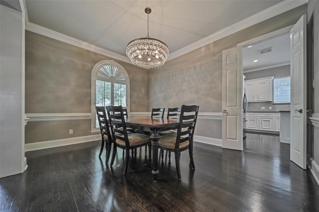 A dining room with a table and chairs and a chandelier.