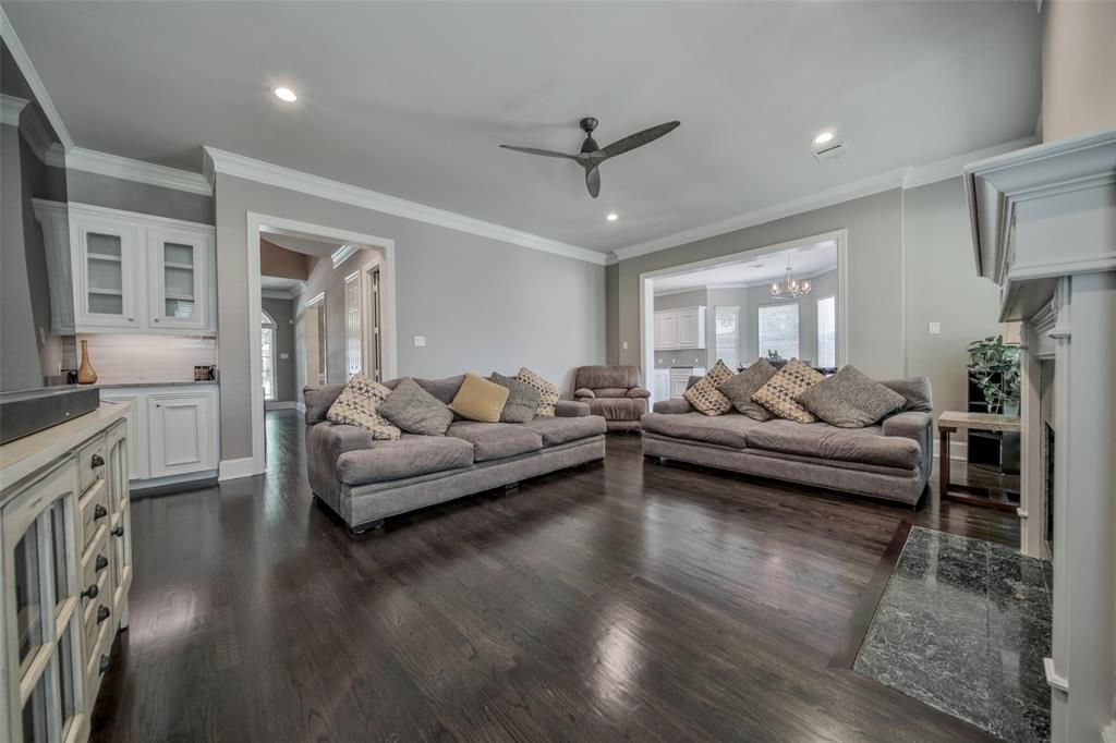 A living room with two couches, a fireplace, and a ceiling fan.