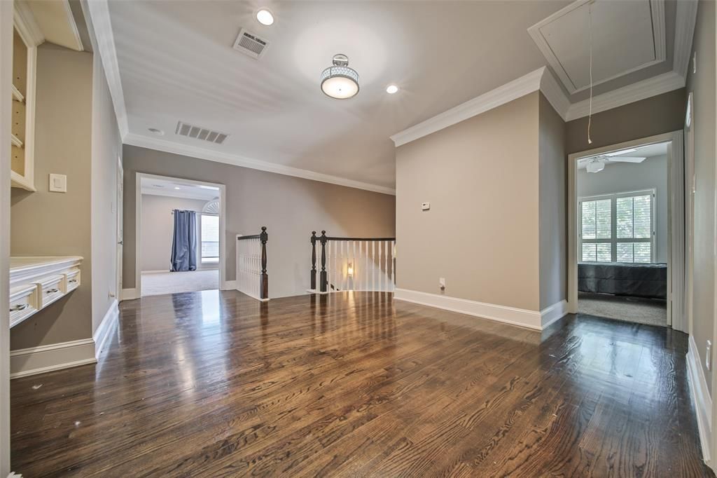 An empty living room with hardwood floors and a staircase leading to the second floor.