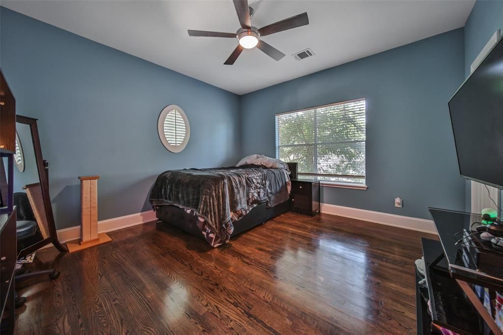 A bedroom with a bed and a ceiling fan.