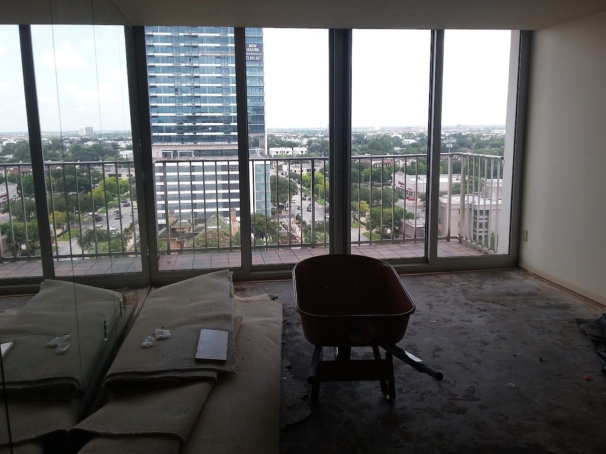 An empty room with a wheelbarrow in front of a large window