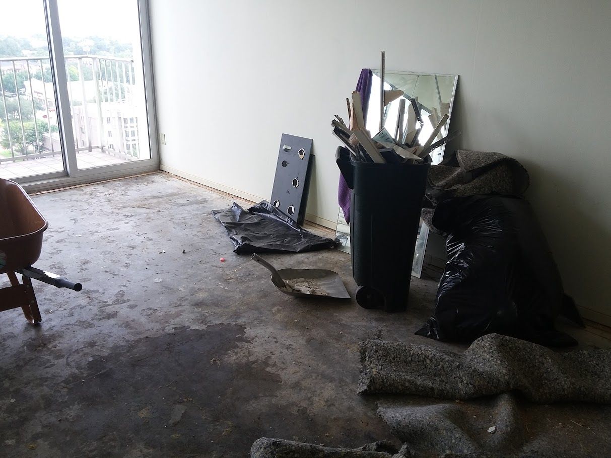 A room with a trash can and a mirror on the wall