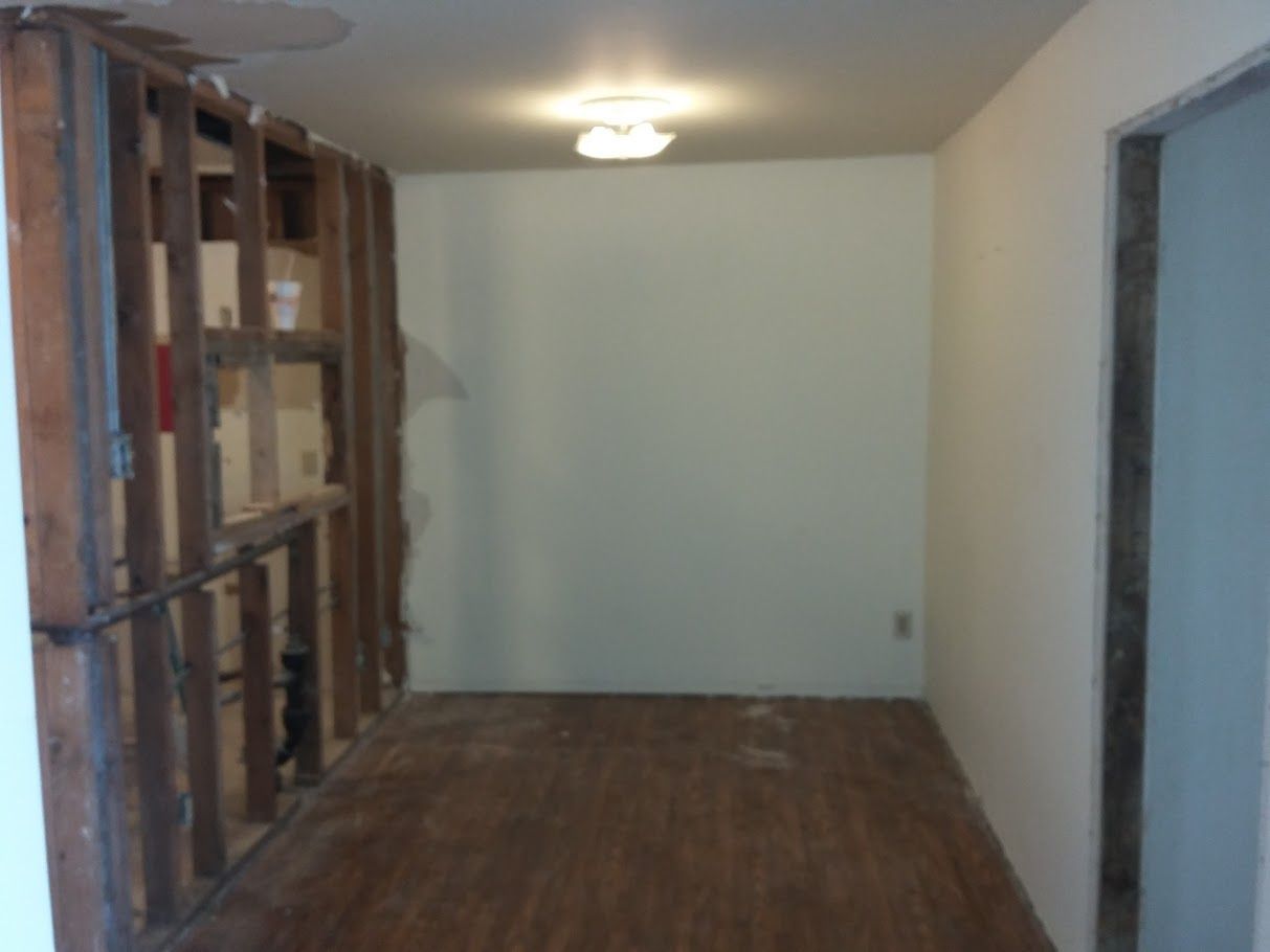 A hallway with a wooden floor and white walls