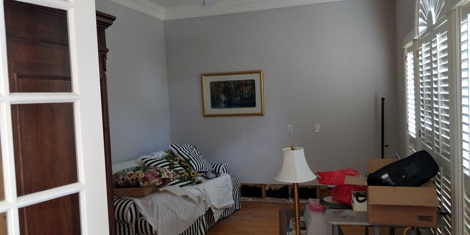 A living room with a couch and a lamp.